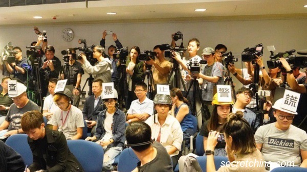 6名记者分别戴上贴上不同字的头盔出席记者会，表达不满警方在连日的行动中粗暴对待记者。