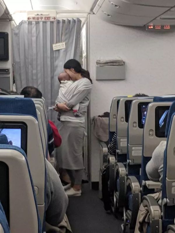 飞机上抱着宝宝的妈妈