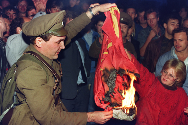 1991年8月23日，一名穿着军装的男子在莫斯科烧毁苏联国旗。