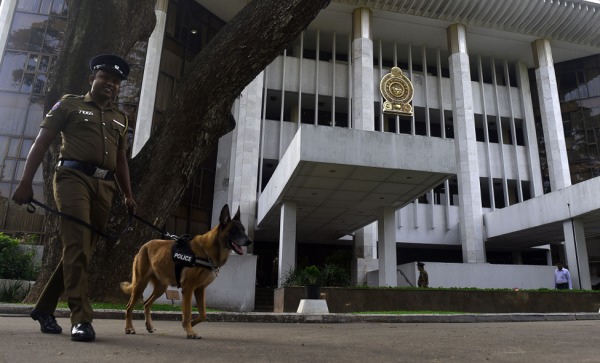 2018年12月12日，一名斯里蘭卡警察帶著一條嗅探狗在斯里蘭卡最高法院外面巡視。
