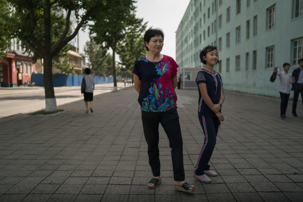 2017年9月24日拍摄的一张照片中，一名妇女和儿童站在平壤的一条街道上。