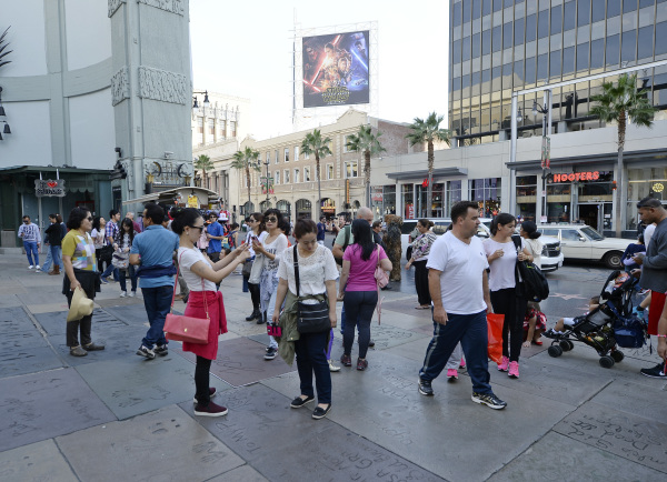 2015年12月8日，洛杉矶中国游客在参演《星球大战》的影星留下的手印足印地拍照留念。