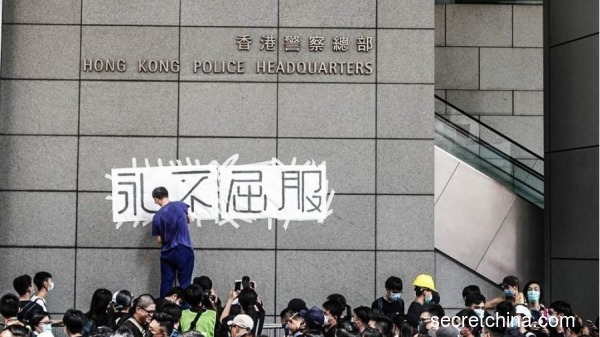 圖為2019年6月，反送中期間示威者包圍警察總部，並在外牆貼上「永不屈服」四個字。（圖片來源：李天正/看中國）