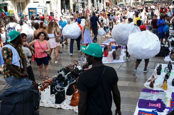 2016年7月30日，巴塞羅那Canaletas附近的非法街頭市場，商販在兜售假冒商品。