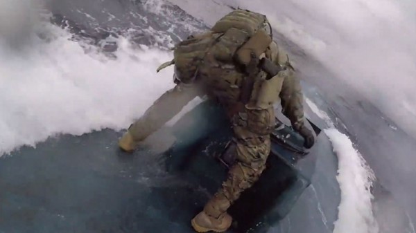 一名英勇的海警隊員直接跳上半潛艇，用力敲擊並打開艙門，迫使毒販投降。
