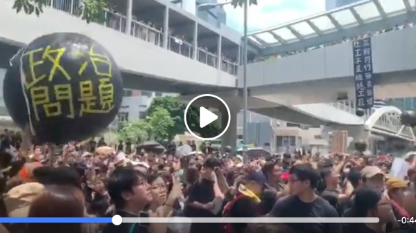 香港多个社福团体21日发起“社工受够了”静默游行，参加者自制道具，在巨型黑色汽球上写着“政治问题”。