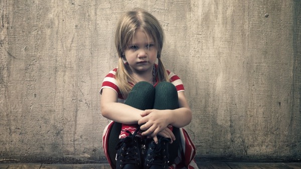清冷的医院走廊里，靠墙根蹲着一个小女孩。