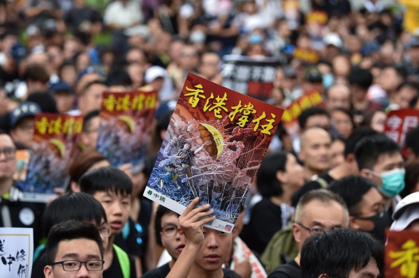 7月7日，23万香港人参加了九龙“反送中”游行，游行人士手持《看中国》印刷的“香港撑住”画报。