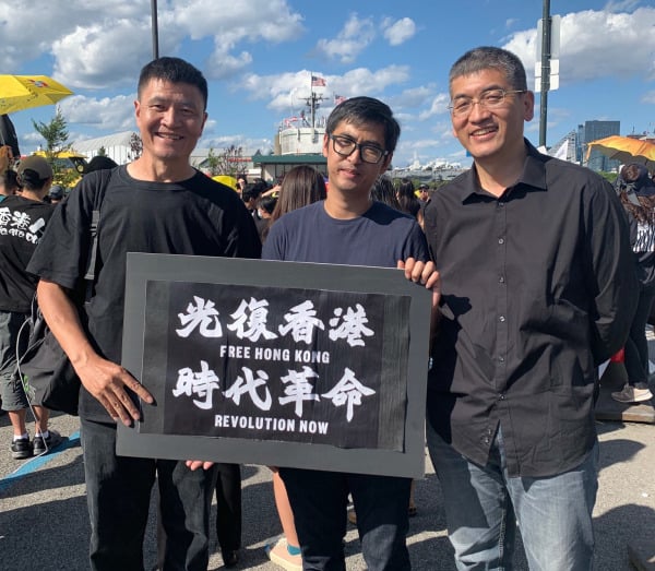 2019年8月10日（週六）下午，在中國駐紐約總領事館前的廣場上，一群關心香港局勢的華裔民眾舉行了聲援「反送中」的示威活動。圖為周鋒鎖（左）、周永康（中）、鄭旭光（右）。