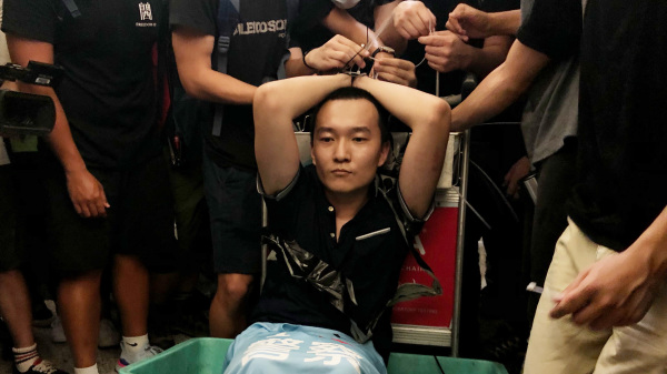 图为前《环球时报》记者付国豪2019年8月在滋扰香港示威人士后遭捆绑。（图片来源：Getty Images）