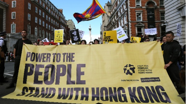 人们在英国伦敦市中心参加由StandwithHK和D4HK组织的游行活动，以支持2019年8月17日在香港举行的民主抗议活动。（照片来源：ISABEL INFANTES / AFP / Getty Images）