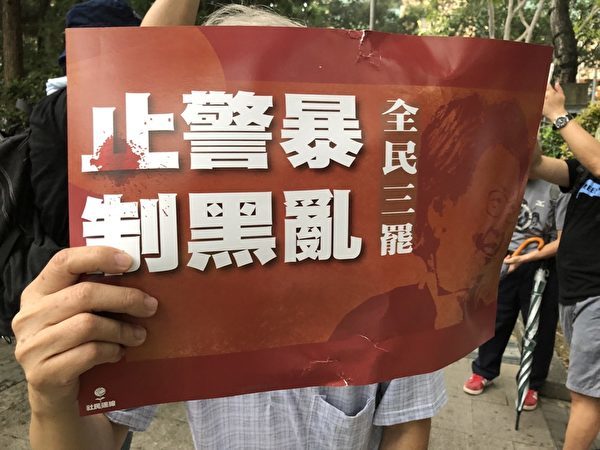 李大伯手持标语，他表示，“没有了共产党，香港才会好。”