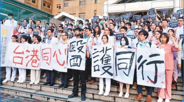 上百名台灣醫護人員在台大醫院正門外階梯處，一同呼喊「台港同心，醫護同心」口號。