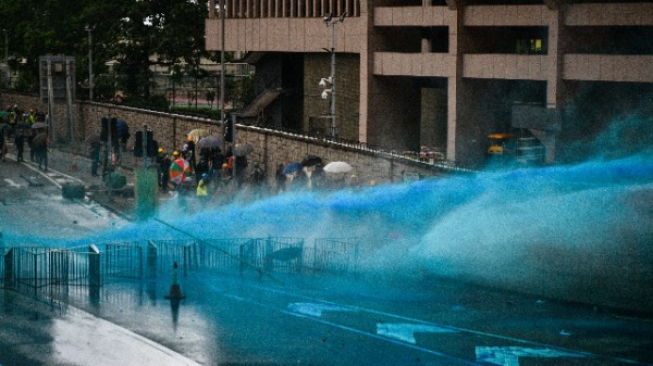 2019年8月31日，港警向香港政府总部附近的抗议者发射蓝色水炮。（照片来源：ANTHONY WALLACE / AFP / Getty Images）